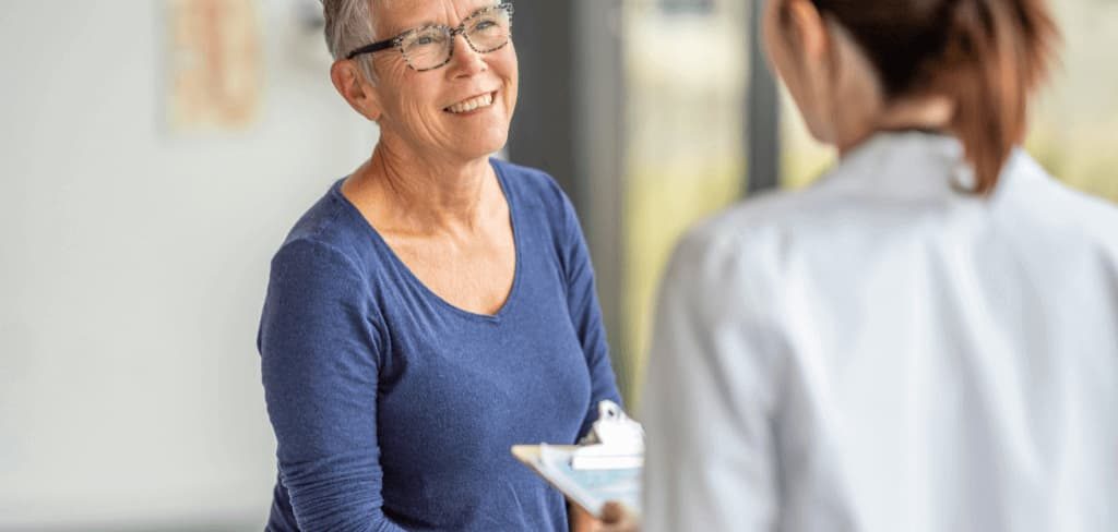 doctora-check-up-paciente Doctora realizando check-up a mujer sonriente.