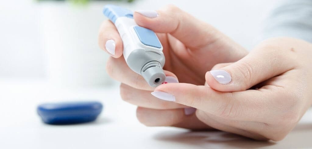 medicion-glucosa-diabetes Mujer midiendo glucosa en sangre con glucómetro azul