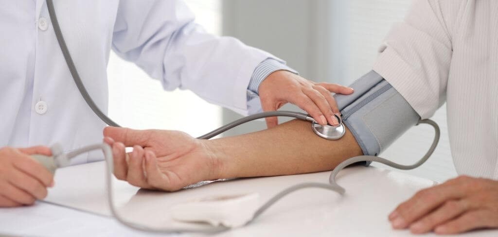 toma-presion-arterial Médico tomando la presión a paciente con estetoscopio